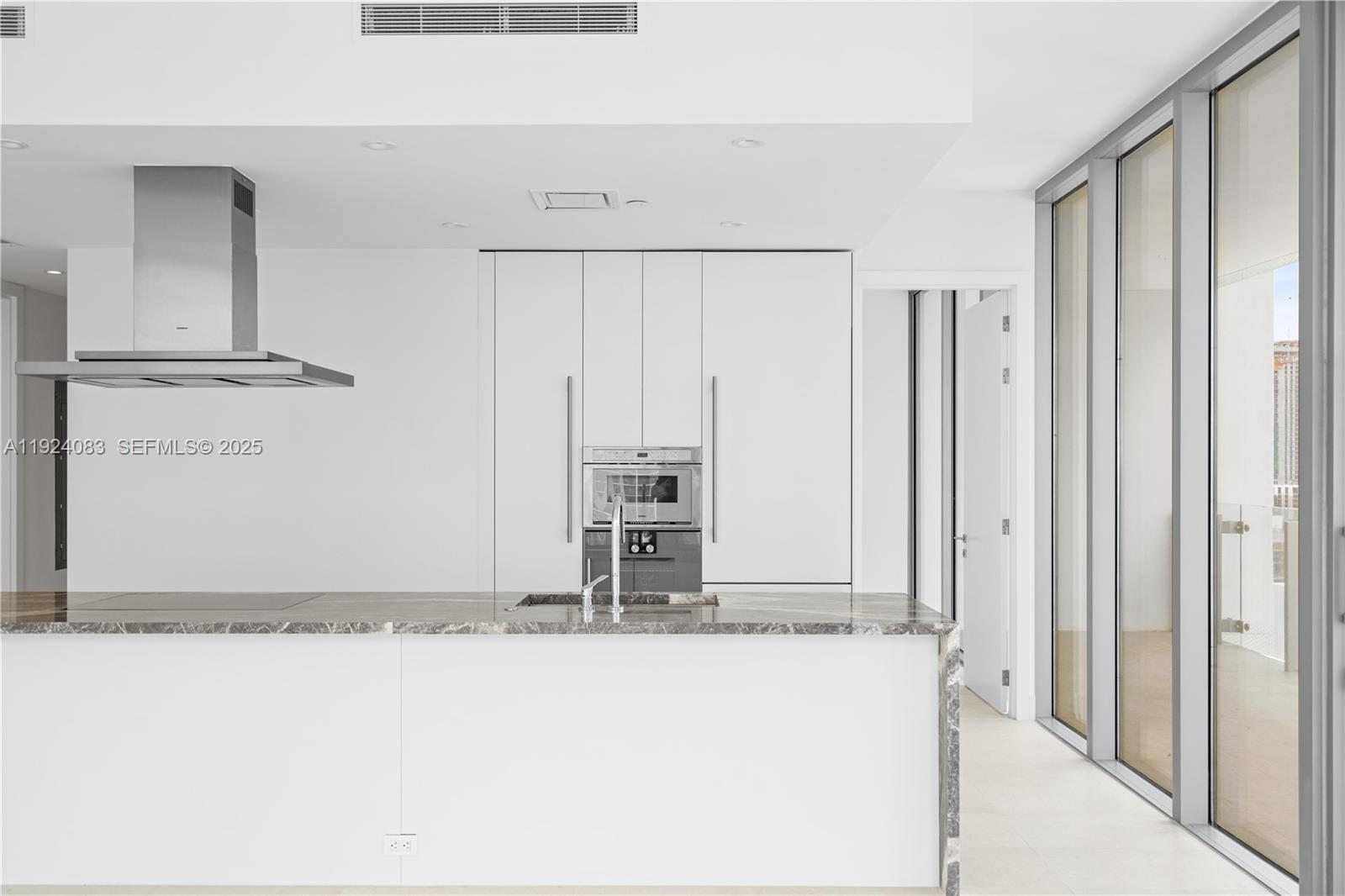 700 Northeast 26th Terrace, Unit 1406 Miami, FL 33137 - Photo 5 of 41 a bathroom with a granite countertop sink and a mirror