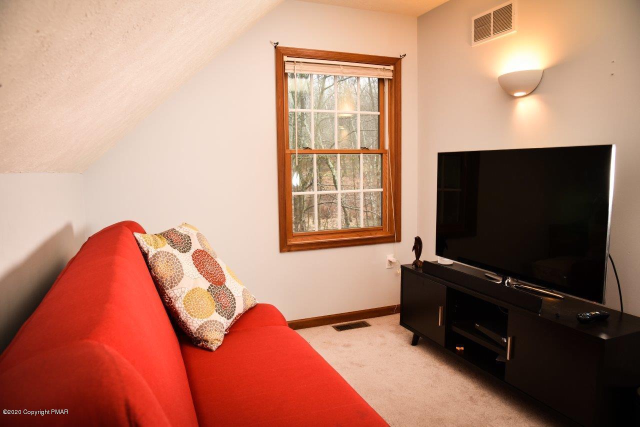 264 Kirkham Road Bushkill, PA 18324 - Photo 16 of 21 a living room with a flat screen tv on dresser and a window