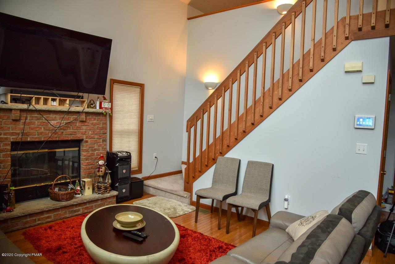 264 Kirkham Road Bushkill, PA 18324 - Photo 6 of 21 a view of a livingroom with furniture a fireplace wooden floor and windows