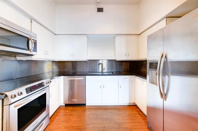 a kitchen with stainless steel appliances a stove microwave and sink