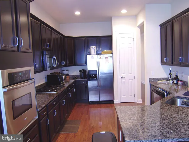 a kitchen with granite countertop stainless steel appliances and wooden cabinets