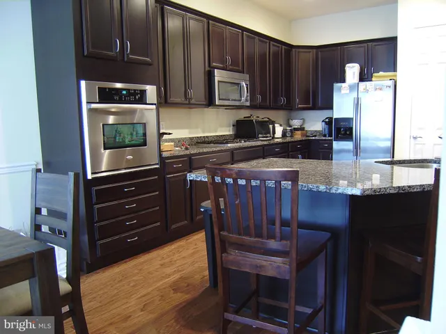a kitchen with granite countertop wooden cabinets and stainless steel appliances