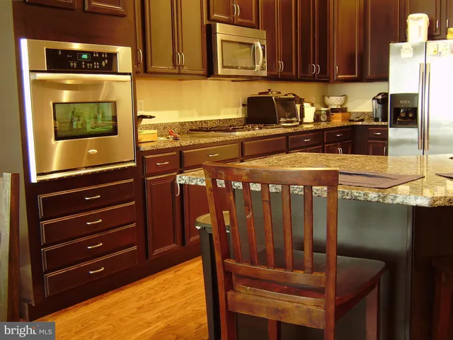 a kitchen with stainless steel appliances granite countertop a stove a microwave and a refrigerator