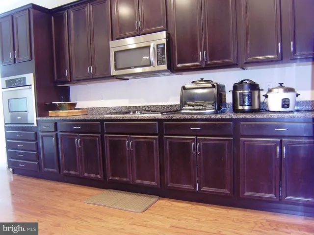 a kitchen with stainless steel appliances granite countertop wooden cabinets a sink and dishwasher