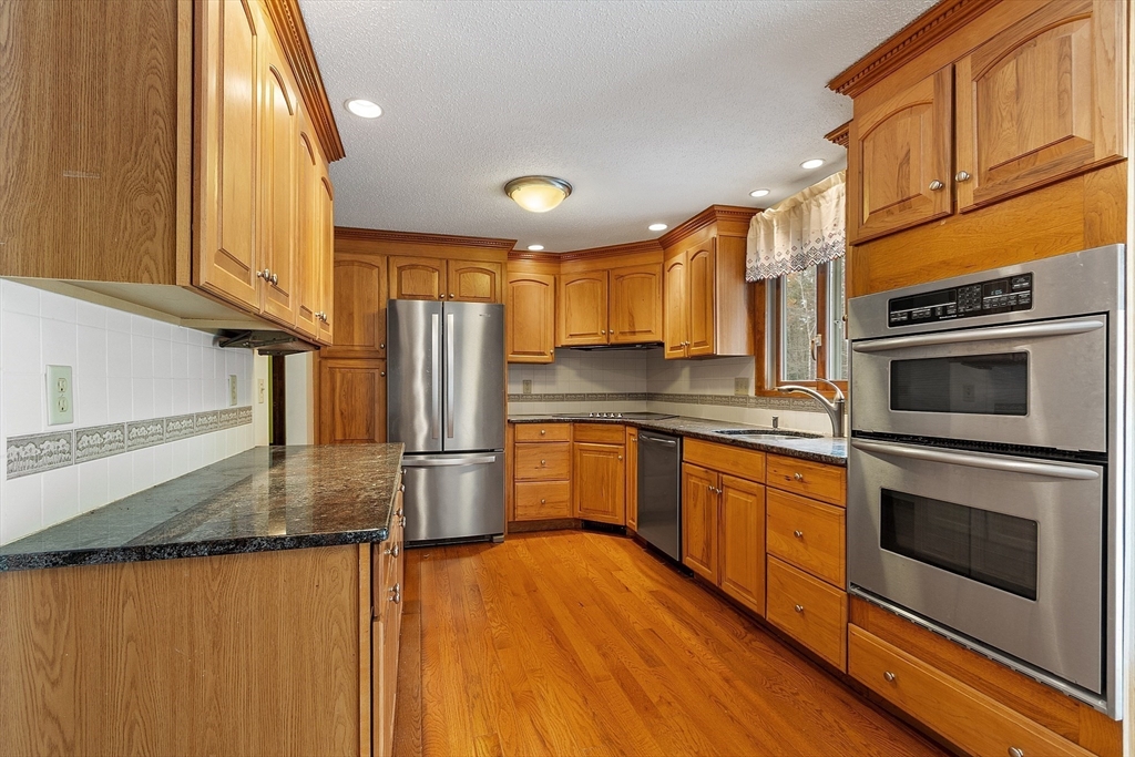 80 A Nashua Road Pepperell, MA 01463 - Photo 4 of 19 a kitchen with stainless steel appliances granite countertop a refrigerator a stove and a sink with wooden floor