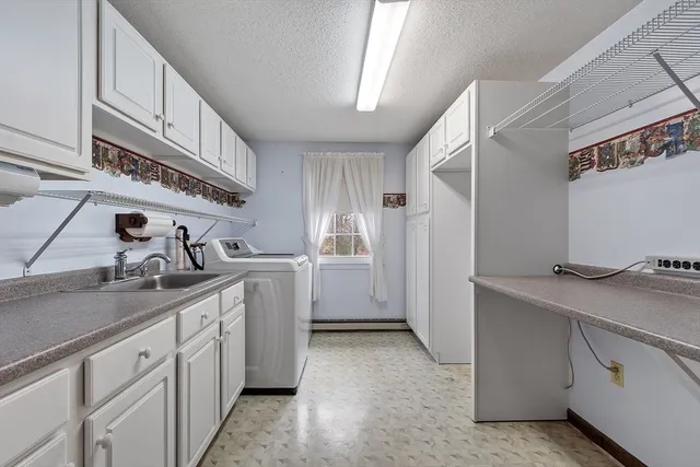 a kitchen with white cabinets and sink