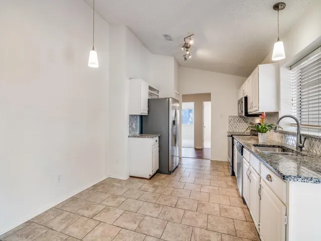 a kitchen with stainless steel appliances a sink stove and refrigerator