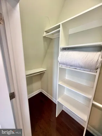 a view of walk in closet with empty racks