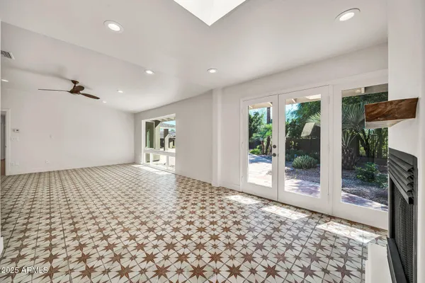 a view of an empty room with wooden floor and windows