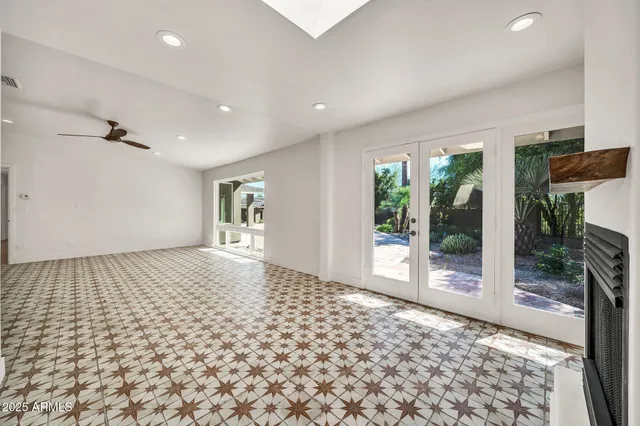 a view of an empty room with wooden floor and windows