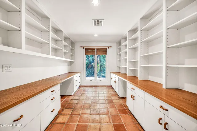 an empty room with a ceiling fan and window