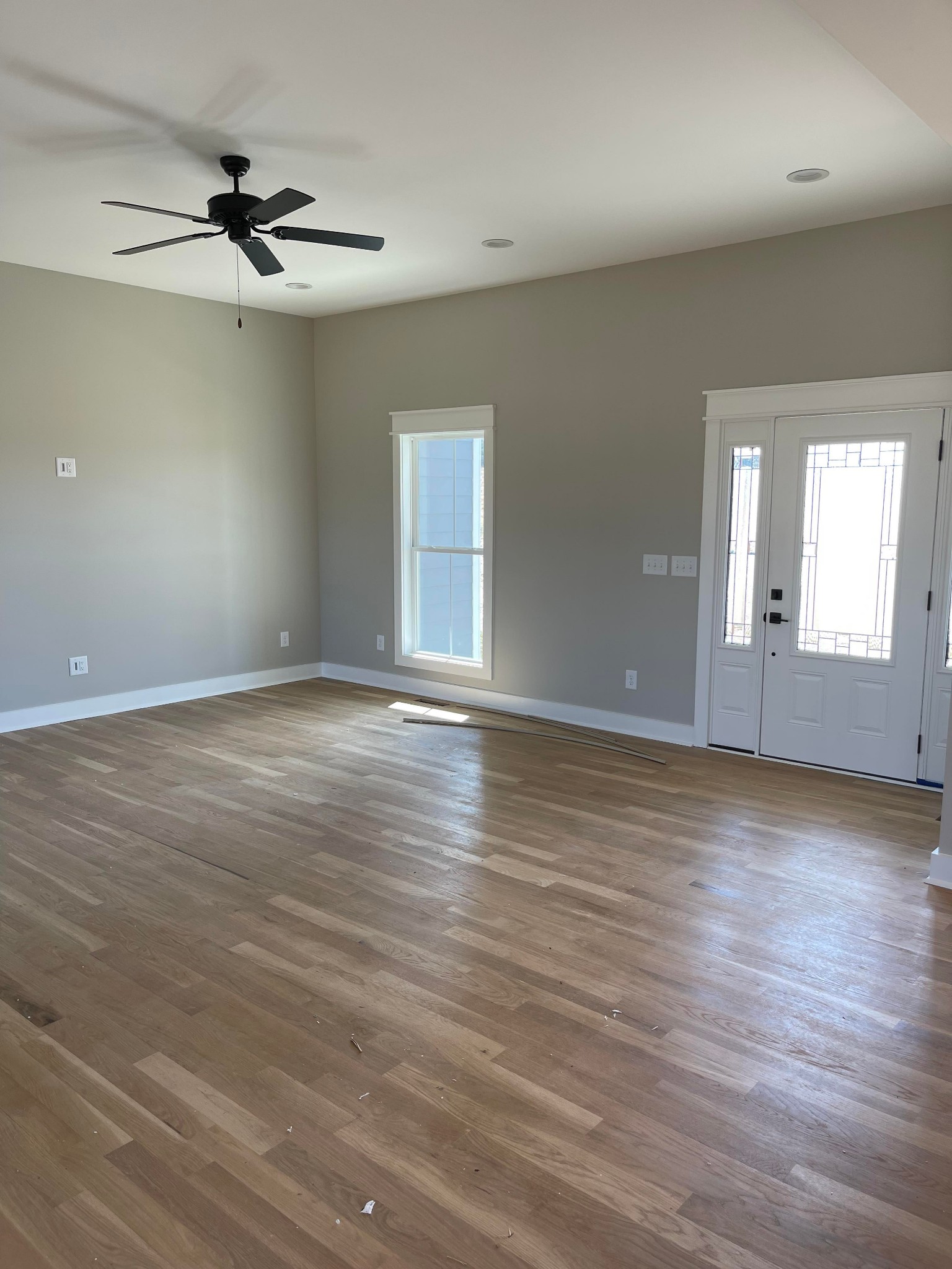 106 Freeland Road Portland, TN 37148 - Photo 3 of 23 an empty room with wooden floor chandelier fan and windows
