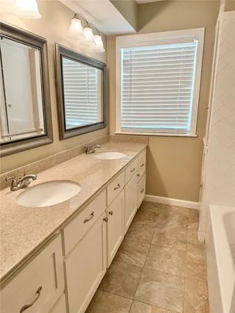 a bathroom with a granite countertop sink and a window