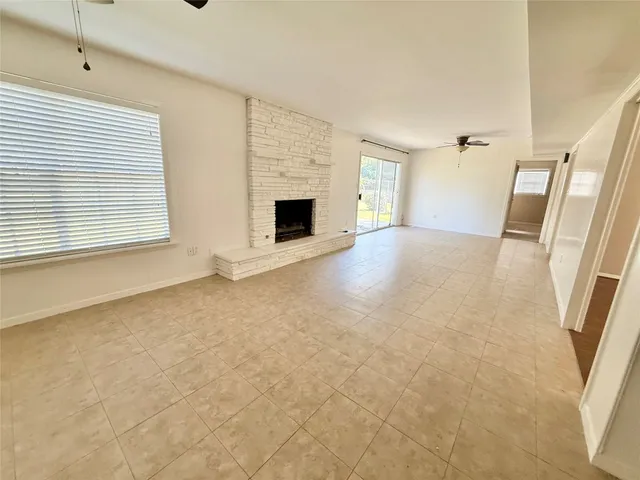 a view of an empty room with a fireplace and a window