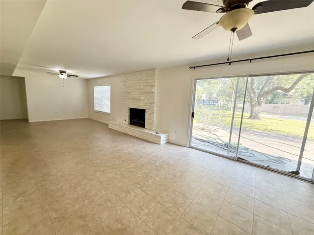 a view of an empty room with a fireplace and a window