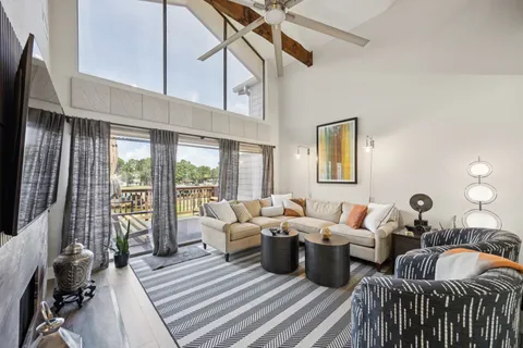 a living room with lots of furniture and a floor to ceiling window