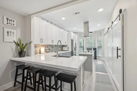 a kitchen with a refrigerator a sink and a stove top oven