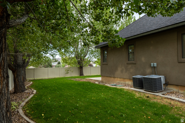 3565 West 1350th Street North Vernal, UT 84078 - Photo 52 of 54 Expansive green lawn framed by mature trees, featuring a light-toned privacy fence