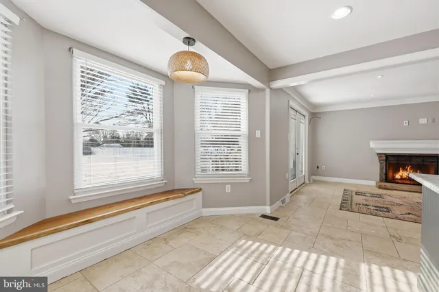 a view of an empty room with a fireplace and a window