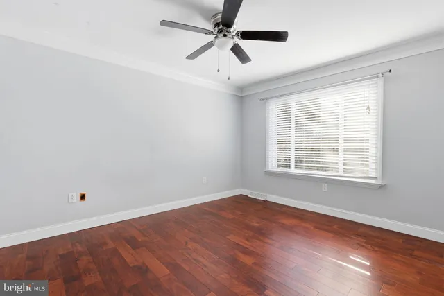 an empty room with a window and a ceiling fan