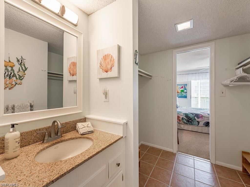 1 Bluebill Avenue, Unit 709 Naples, FL 34108 - Photo 11 of 30 a bathroom with a granite countertop sink and a mirror