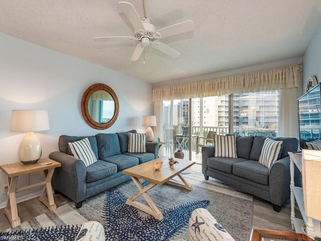 1 Bluebill Avenue, Unit 709 Naples, FL 34108 - Photo 4 of 30 a living room with furniture a rug potted plant and a large window