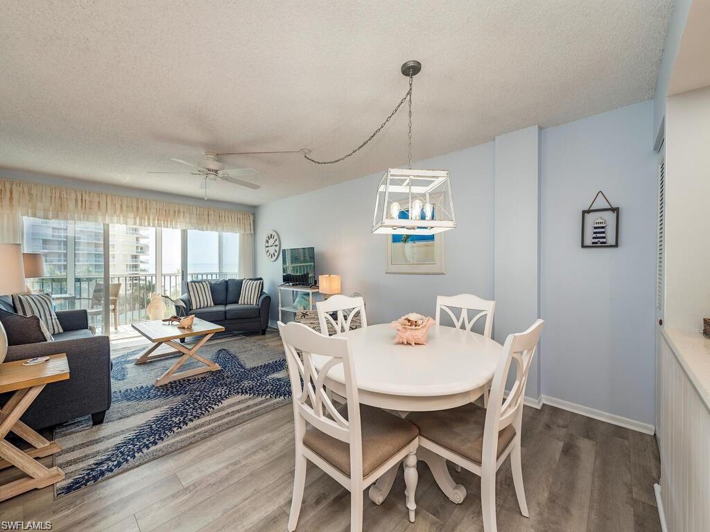 1 Bluebill Avenue, Unit 709 Naples, FL 34108 - Photo 5 of 30 a view of a dining room with furniture wooden floor and chandelier