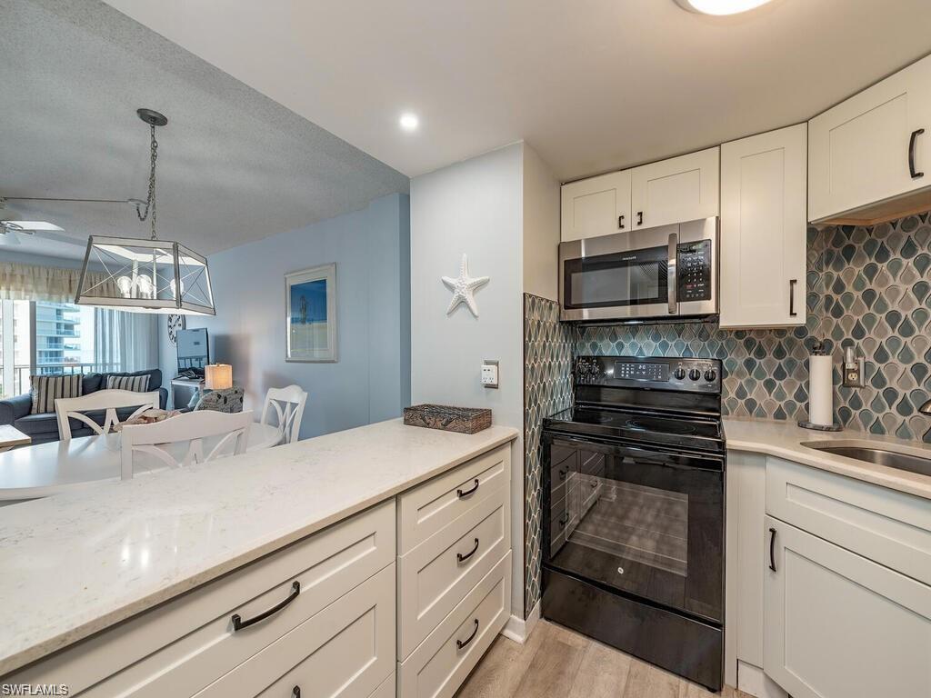 1 Bluebill Avenue, Unit 709 Naples, FL 34108 - Photo 6 of 30 a kitchen with appliances a sink and cabinets