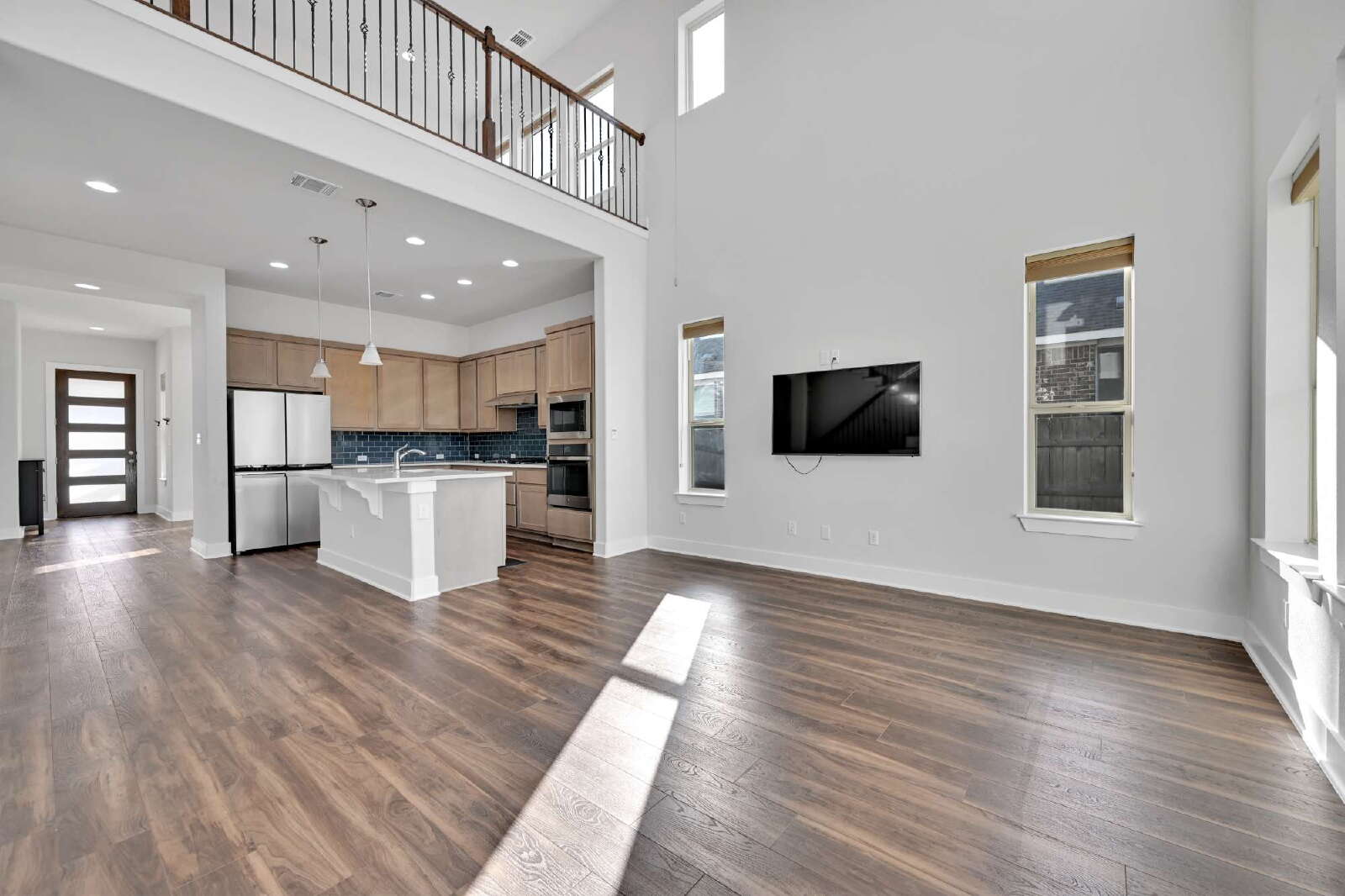 4420 Kings Cross Road Pflugerville, TX 78660 - Photo 6 of 25 Double-height ceilings and rich wood floors define this light-filled, open-concept living space.