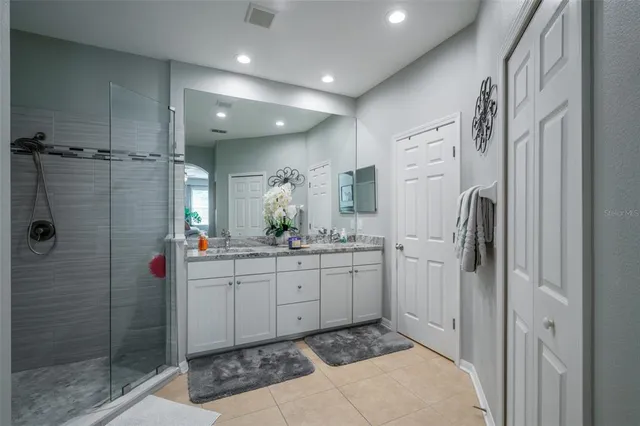 a bathroom with a granite countertop sink a mirror and shower