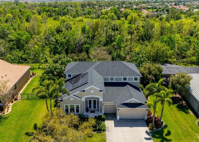 an aerial view of a house with a yard and swimming pool