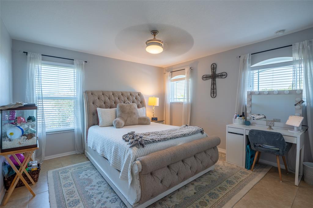 309 Royal Bonnet Drive Apollo Beach, FL 33572 - Photo 32 of 59 a bedroom with a bed and a table in it with window