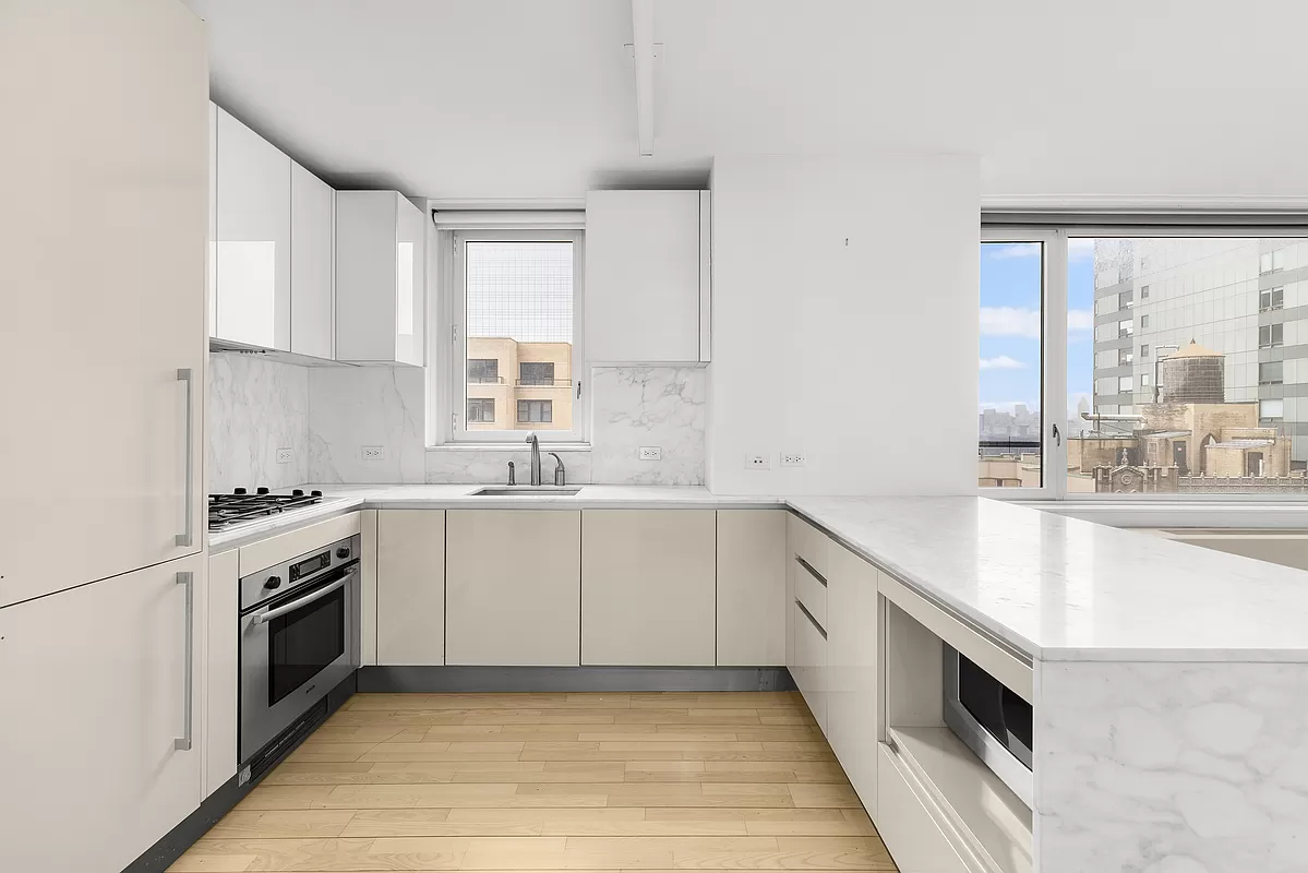 322 West 57th Street, Unit 25H Manhattan, NY 10019 - Photo 2 of 9 a kitchen with granite countertop white cabinets and white appliances