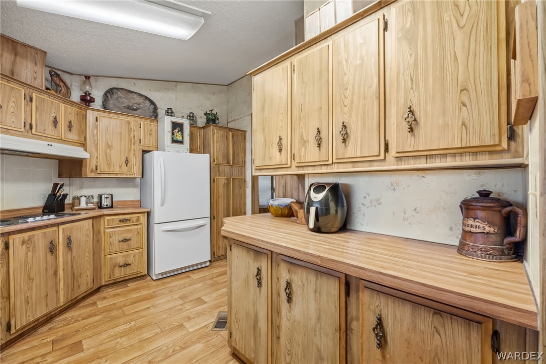 10031 Dike Road Mohave Valley, AZ 86440 - Photo 57 of 78 a kitchen with refrigerator and cabinets