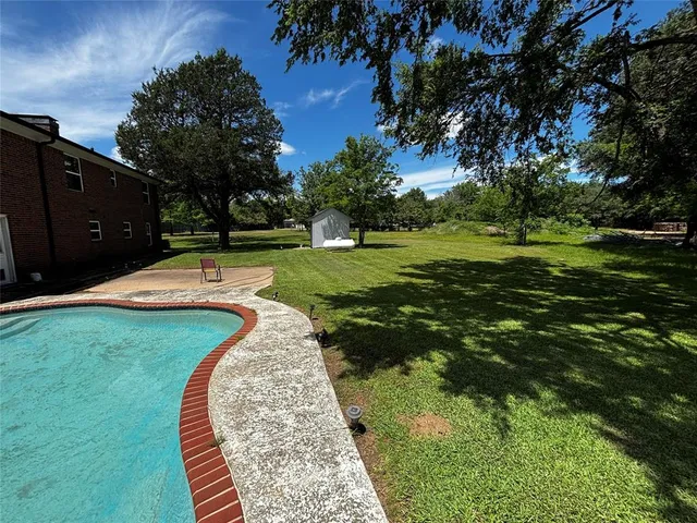 a view of a swimming pool with a yard