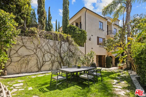 a backyard of a house with table and chairs