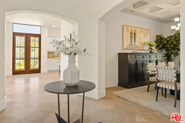 a view of a livingroom with furniture a chandelier and wooden floor