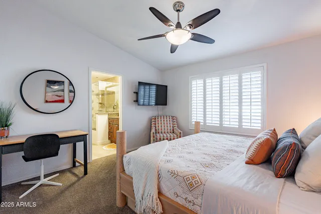 a bedroom with a granite countertop sink and a mirror