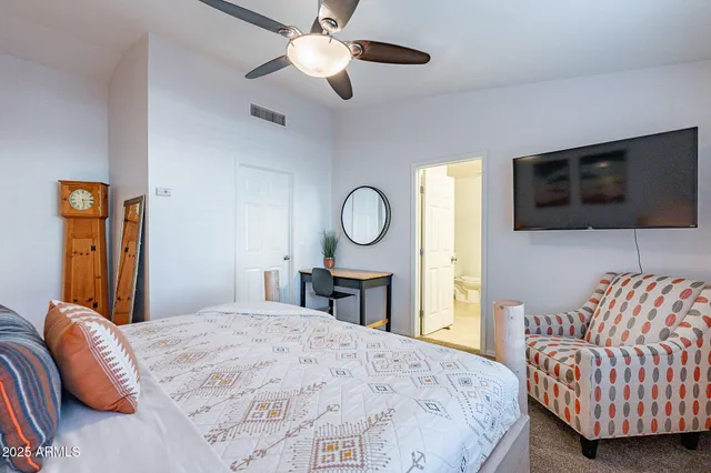 a bedroom with a bed and painting on the wall