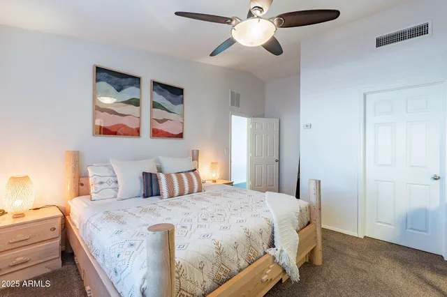 a bedroom with a bed and a chandelier fan