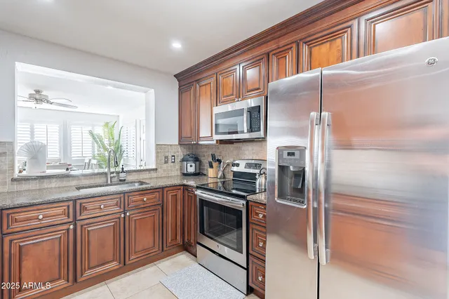 a kitchen with stainless steel appliances granite countertop a refrigerator and a sink