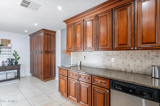 a kitchen with kitchen island granite countertop a sink cabinets and window