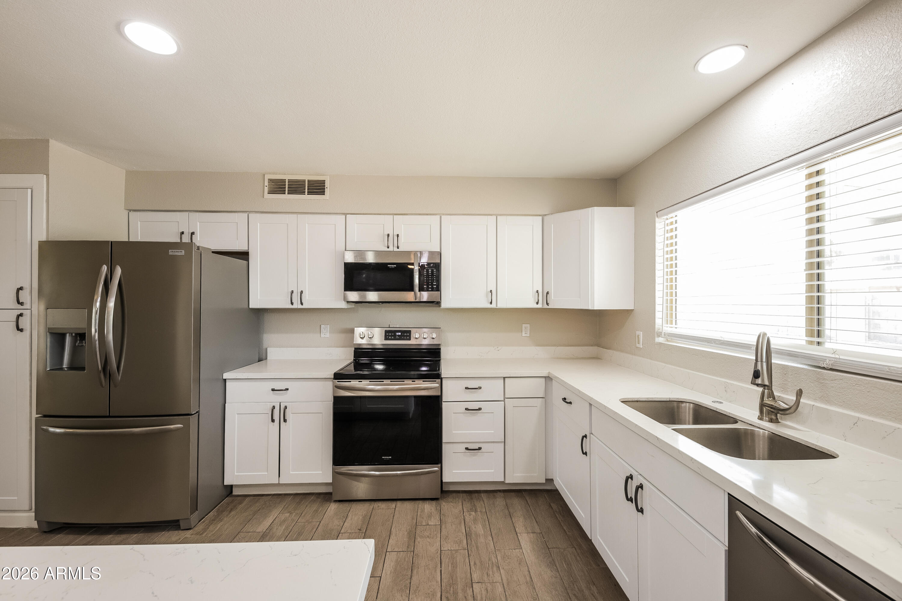 2501 East Villa Rita Drive Phoenix, AZ 85032 - Photo 2 of 15 a kitchen with stainless steel appliances a sink cabinets and a window