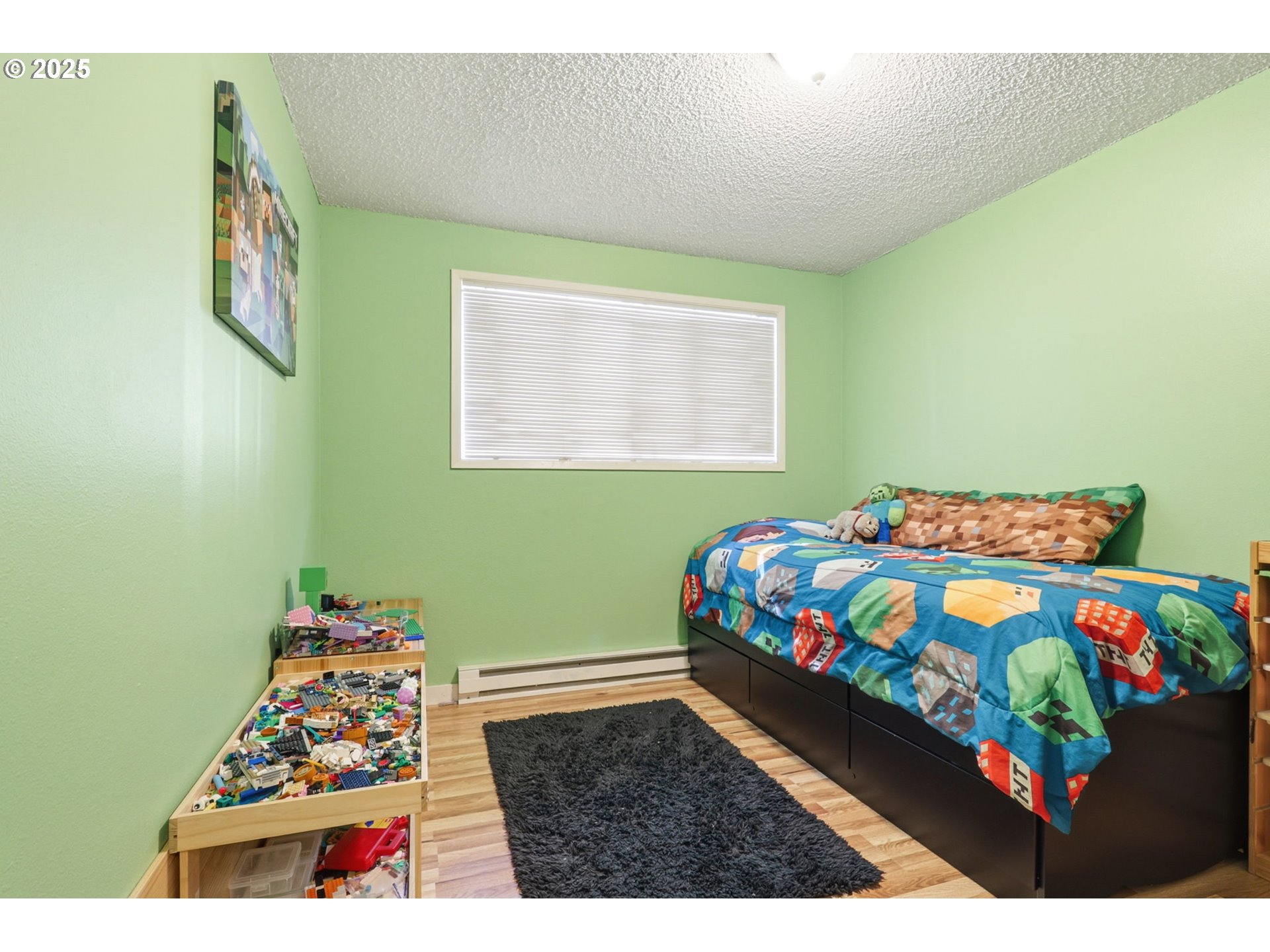 1123 Northwest Ash Street Camas, WA 98607 - Photo 17 of 26 a bedroom with a bed that has a blanket on it and next to a wall