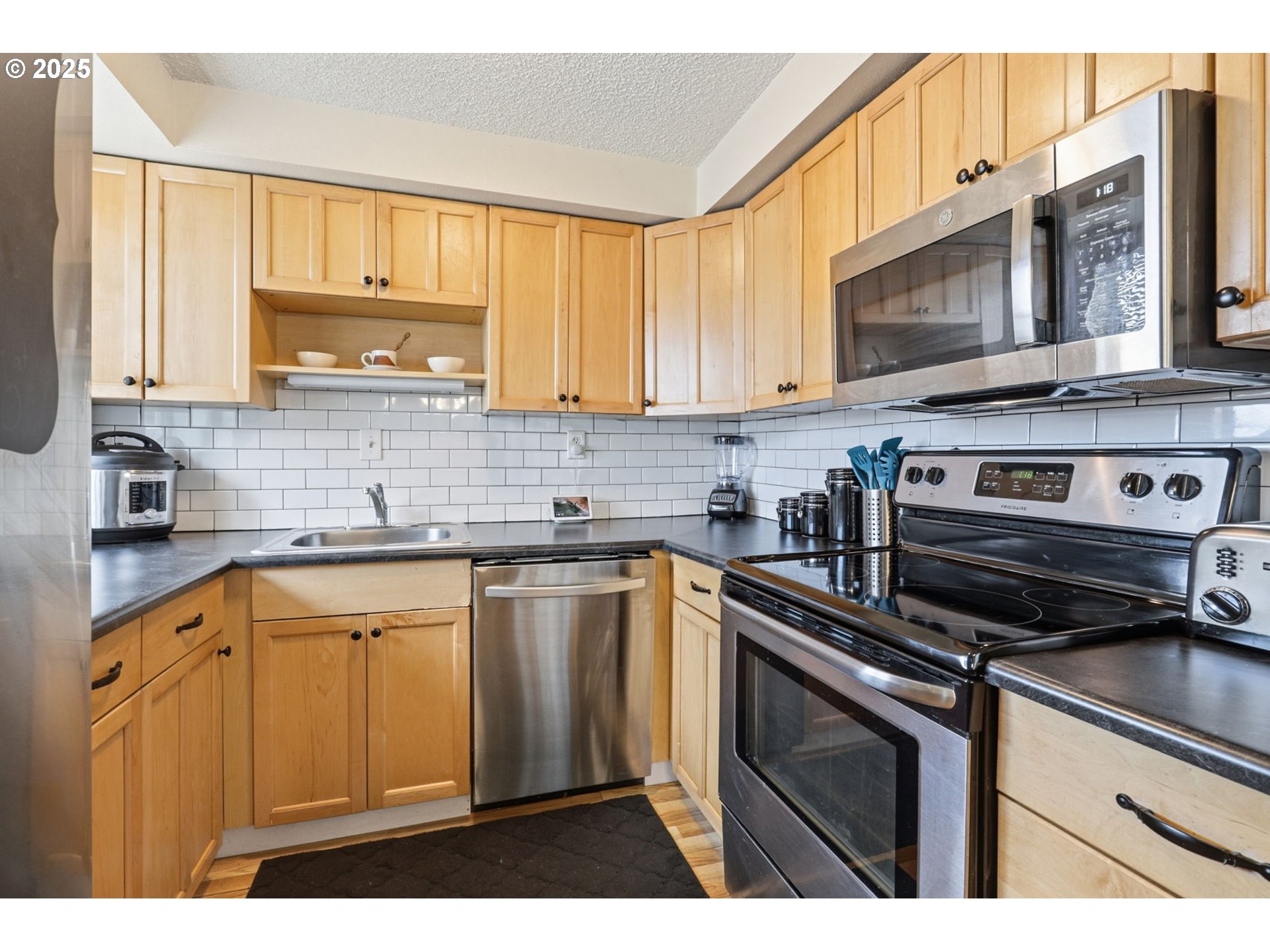 1123 Northwest Ash Street Camas, WA 98607 - Photo 10 of 26 a kitchen with stainless steel appliances granite countertop a sink stove and microwave