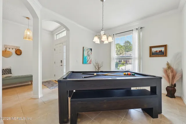 a living room with a table chairs and a chandelier
