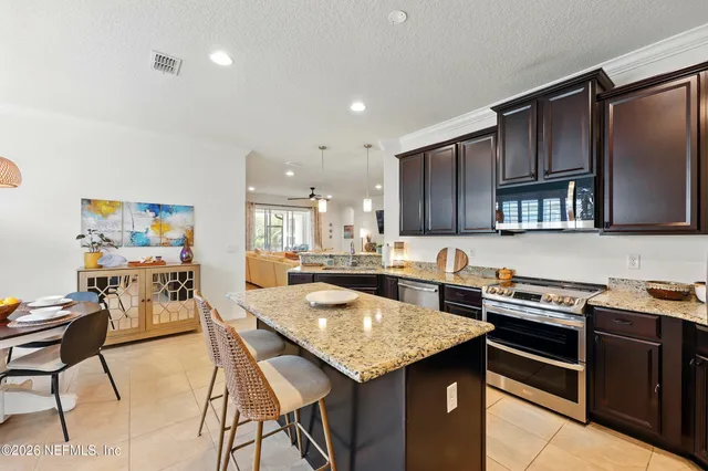 a kitchen with a stove a kitchen island and chairs in it