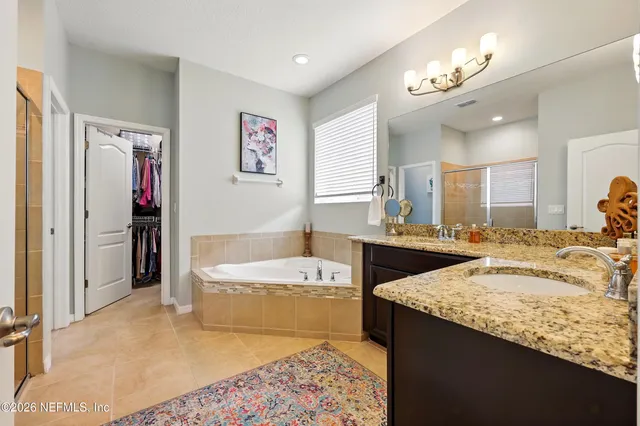 a spacious bathroom with a granite countertop sink and a mirror