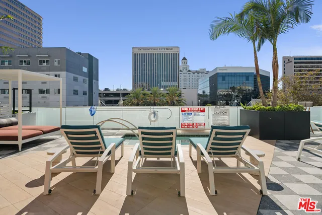 a roof deck with couches and potted plants