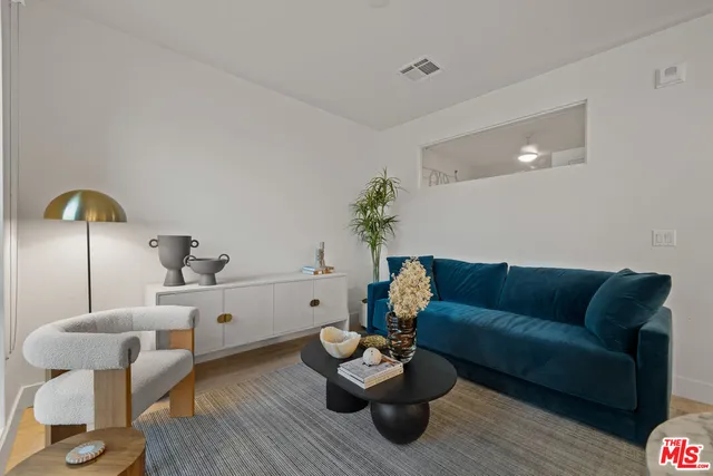 a living room with furniture and kitchen view